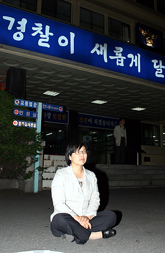 이정희 민주노동당 국회의원이 강서경찰서 안마당에서 연행된 촛불문화제 참가자들에 대한 부당한 대우와 폭행 의혹에 대한 해명을 요구하며 앉아있다.